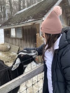 Girl in beanie with goat