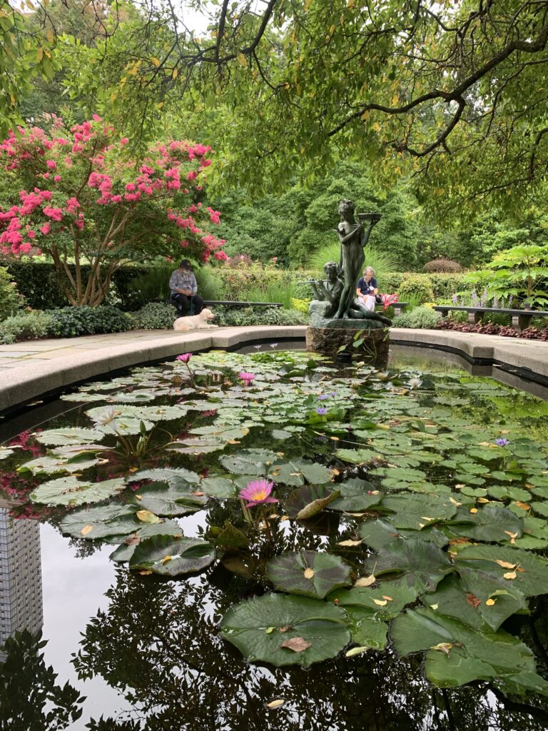 koi pond with statue holding bird bath