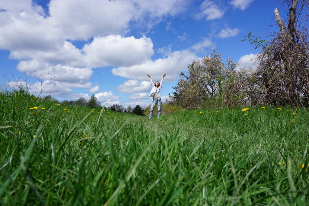 Woman in field raising arms