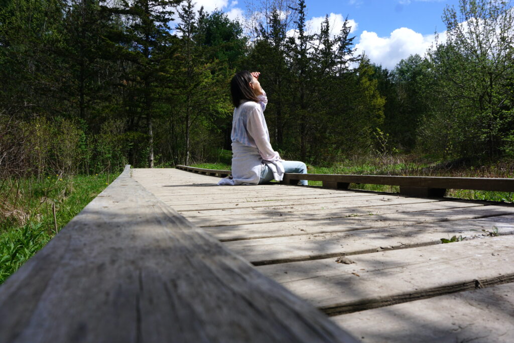 woman sitting on bridge looking up