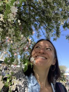 lady next to white tree blossoms