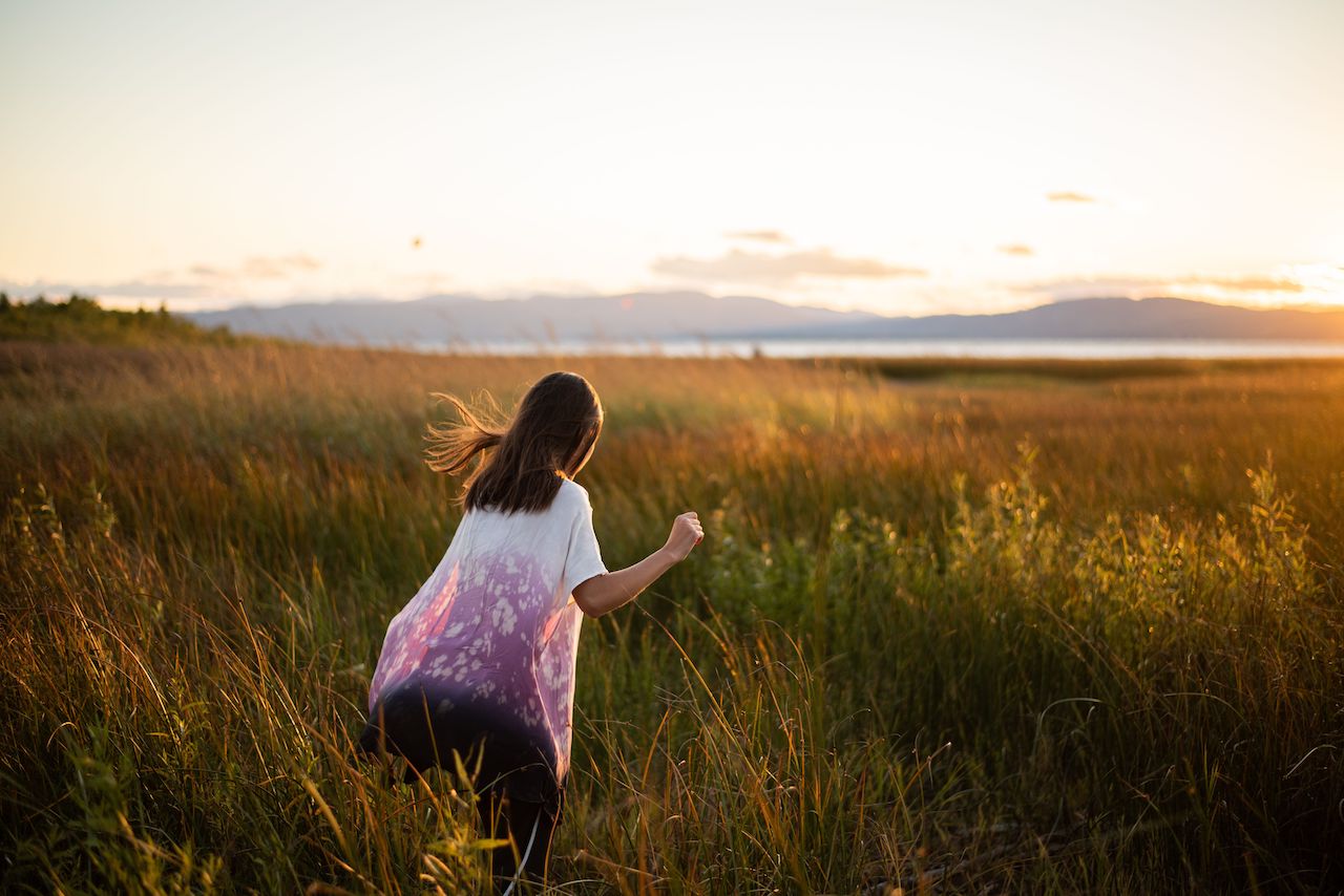 Girl in meadow with sunset