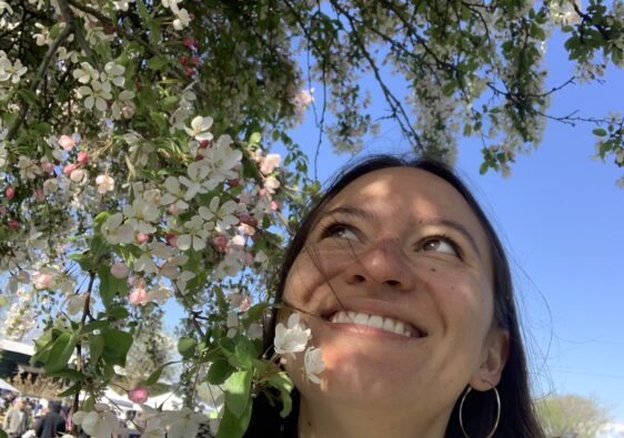 lady next to white tree blossoms