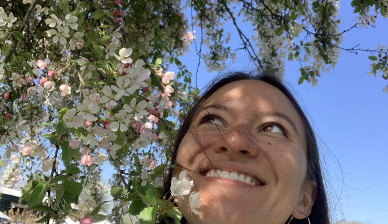 lady next to white tree blossoms